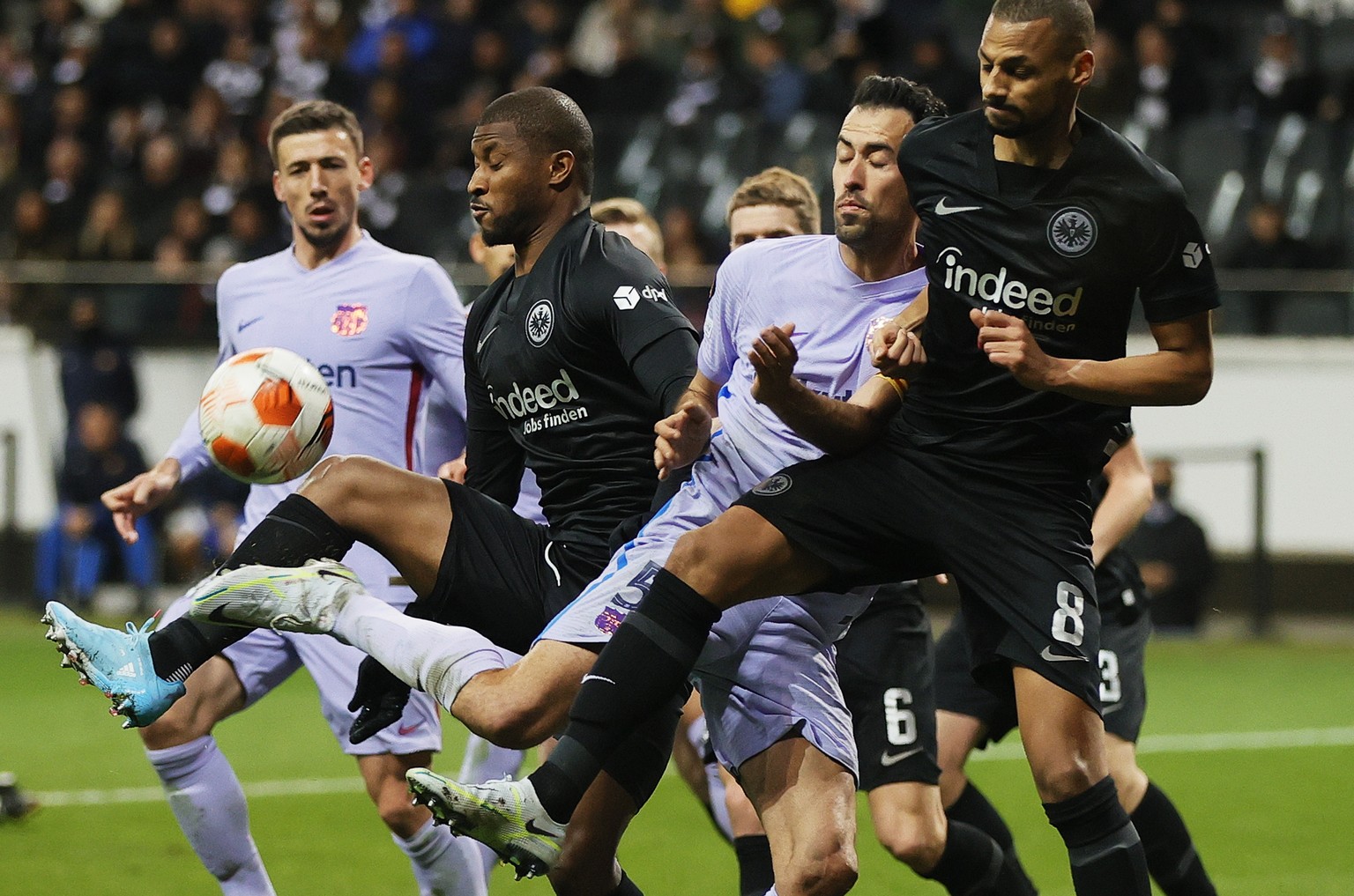 epa09877140 Djibril Sow (R) and Almamy Toure of Frankfurt in action against Sergio Busquets (C) of Barcelona during the UEFA Europa League quarter final, first leg soccer match between Eintracht Frank ...