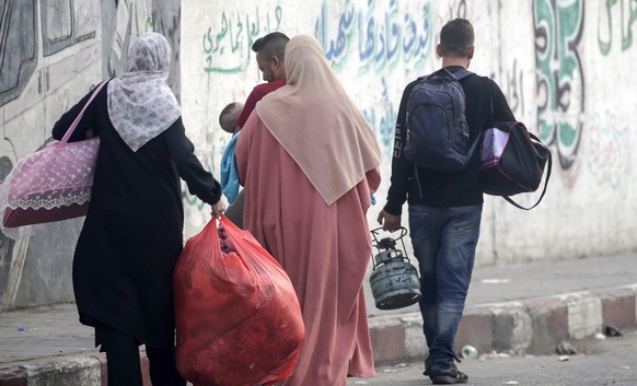 epa10907426 Palestinians carry belongings after they fled following Israeli strikes in the northern and eastern Gaza Strip, in Gaza City, 08 October 2023. According to the UNRWA, over 20,000 Internall ...