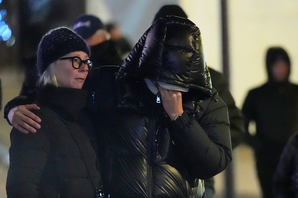 People mourn near the sealed off Le Constellation bar in Crans-Montana, Swiss Alps, Switzerland, Friday, Jan. 2, 2026, where a devastating fire left dead and injured during the New Year's celebra ...