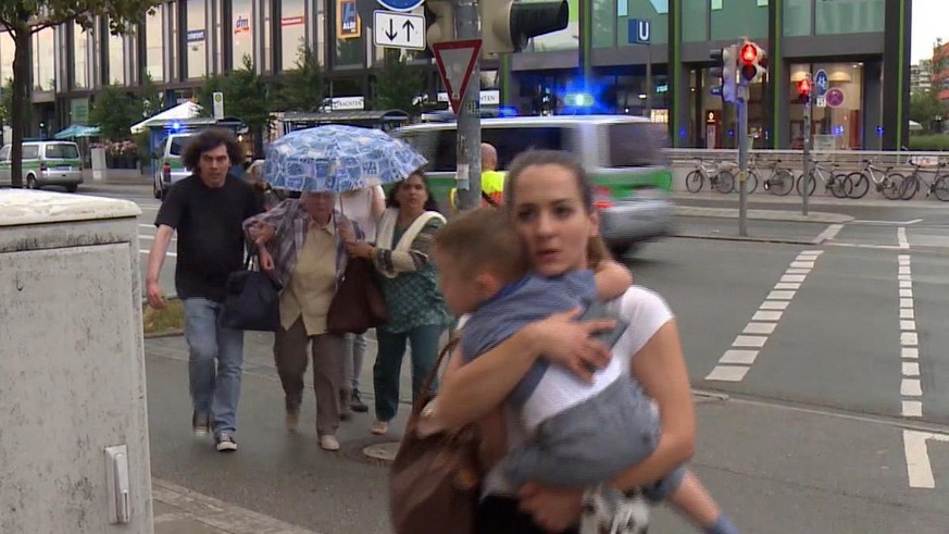 Members of the public run away from the Olympia Einkaufszentrum mall, after a shooting, in Munich, Germany, Friday, July 22, 2016. A manhunt was underway Friday for a shooter or shooters who opened fi ...