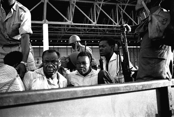 Former Premier Patrice Lumumba, sitiing right, is brought back to Leopoldville under armed guard, with his hands tied behind his back, after his capture in this December 1960 photo. Forty-five years a ...