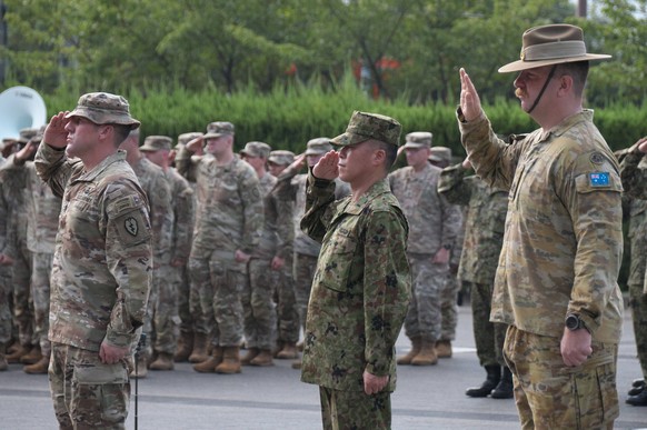 Members of Japan, U.S. and Australian Army salute during the the opening ceremony of Japan, U.S. and Australia joint command post exercise Yama Sakura 89YS-89 at the Camp Itami in Hyogo, Japan on Mond ...