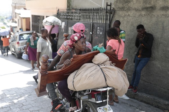 Residents flee their homes to escape clashes between armed gangs in the Carrefour-Feuilles district of Port-au-Prince, Haiti, Tuesday, Aug. 15, 2023. (AP Photo/Odelyn Joseph)