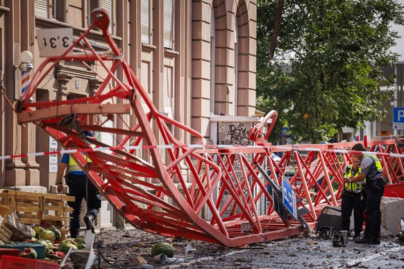 Policemen and firefighters work by a fallen crane after violent storm swept through the city of La Chaux-de-Fonds, Switzerland, Switzerland, Monday, July 24, 2023. A storm swept across part of the can ...