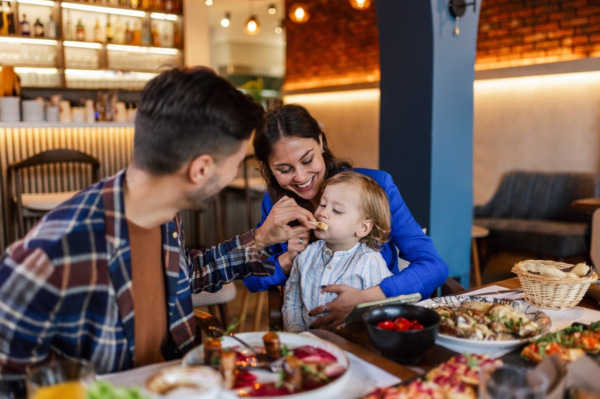 Familie von drei Essen in einem Restaurant leckeres Essen. Speisen- und Getränkekonzept