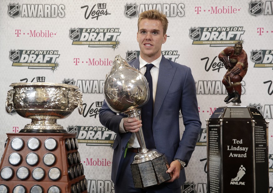 Connor McDavid of the Edmonton Oilers poses with the Art Ross Trophy, left, the Hart Memorial Trophy, center, and the Ted Lindsay Award after winning the honors during the NHL Awards, Wednesday, June  ...