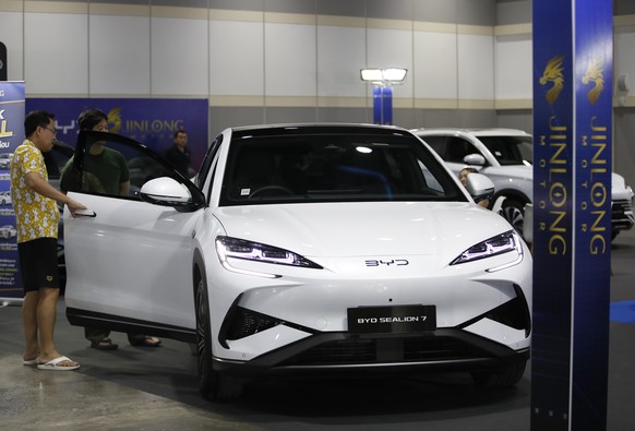 epa12478039 A potential customer inspects a BYD Sealion 7 electric vehicle at the Bangkok EV Expo 2025 in Bangkok, Thailand, 24 October 2025. The event showcases various electric car brands. EPA/RUNGR ...