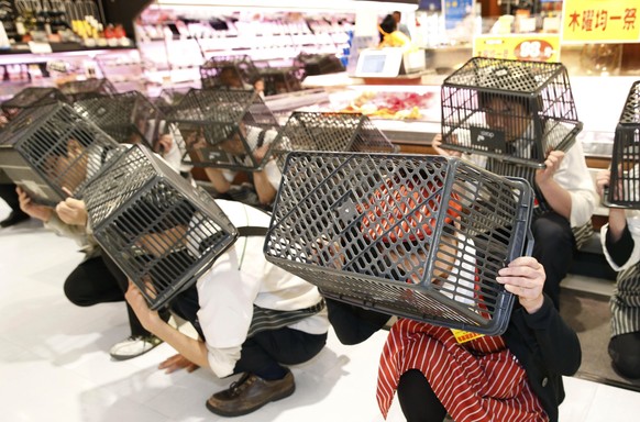 Regel Nummer 1: Den Kopf bedecken – mit dem, was du zur Verfügung hast.
Angestellte eines Supermarkts in Kobe, Japan, während einer Erdbeben-Übung am 14. Januar 2016.