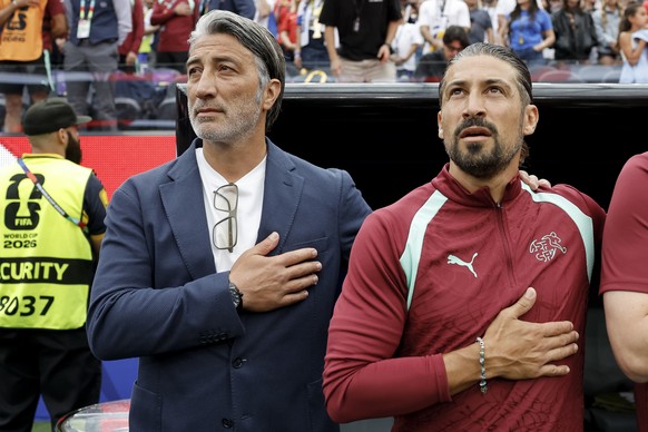 Switzerland's head coach Murat Yakin, left, and Switzerland's assistant coach Davide Calla, right, during the national anthem prior the World Cup Group B soccer match between Switzerland and ...