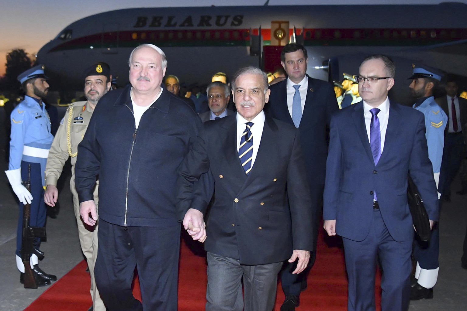 In this photo released by Press Information Department, Pakistan&#039;s Prime Minister Shehbaz Sharif, center, greets Belarusian President Alexander Lukashenko, left, upon his arrival at an airbase in ...