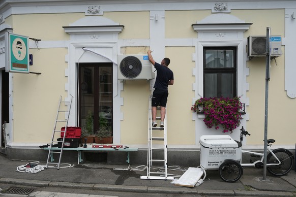 An installer sets a new air conditioning unit during a hot summer day in Belgrade, Serbia, Tuesday, June 30, 2026. (AP Photo/Darko Vojinovic)
Serbia Extreme Weather Heat