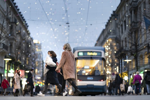 Personen mit Schutzmasken und Einkauftaschen gehen auf der Zuercher Bahnhofstrasse, am Freitag, 27. November 2020, in Zuerich. (KEYSTONE/Gaetan Bally)