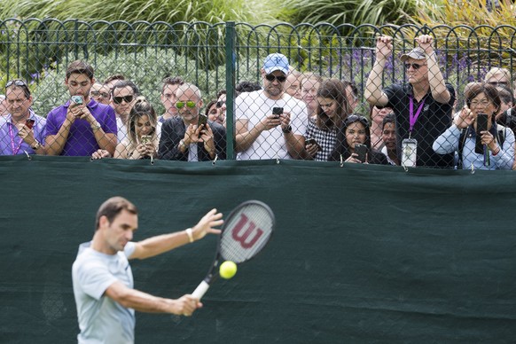 epa06063104 Tennis fans watch Roger Federer of Switzerland during a training session at the All England Lawn Tennis Championships in Wimbledon, London, Britain, 03 July 2017. EPA/PETER KLAUNZER EDITOR ...