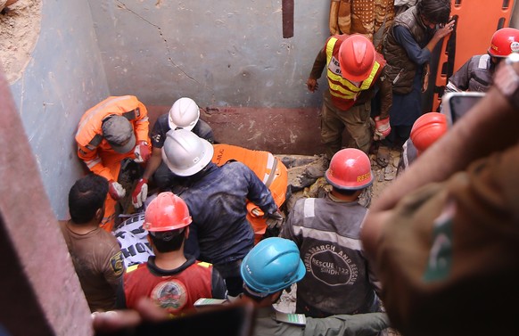 epa12756280 Rescue workers recover the bodies of the victims after a suspected gas leakage blast in Karachi, Pakistan, 19 February 2026. At least 16 people, including women and children, were killed a ...