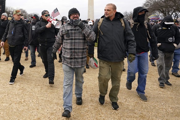 In this Jan. 6, 2021, photo, Proud Boys including Joseph Biggs, front left, walks toward the U.S. Capitol in Washington, in support of President Donald Trump. With the megaphone is Ethan Nordean, seco ...