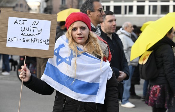 Kundgebung auf dem Helvetiaplatz nach einer Mahnwache in Zuerich am Sonntag, 3. Maerz 2024. Die Menschen trugen gelbe Regenschirme als Symbol gegen Antisemitismus. Am Samstagabend hatte ein Jugendlich ...