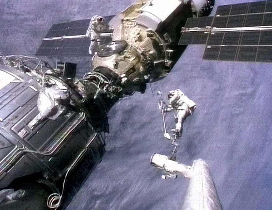 Astronauts Jerry Ross, left, and Jim Newman prepare to unfurl an antenna on the Russian-made international space station module Zarya in this Dec. 9, 1998 image from NASA television. (KEYSTONE/AP Phot ...