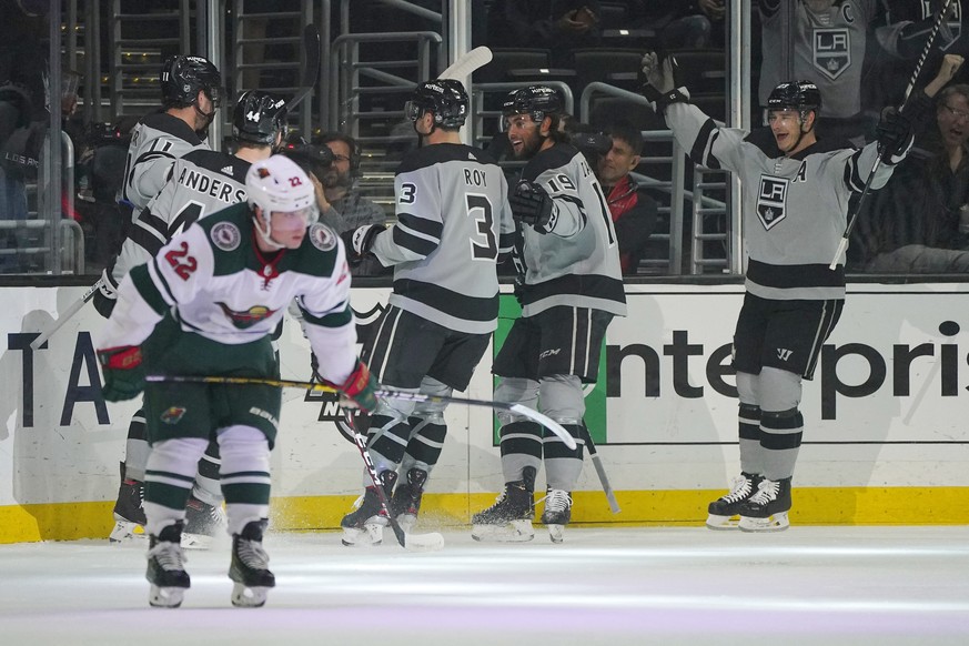 Los Angeles Kings center Anze Kopitar, upper left, celebrates his goal with teammates as Minnesota Wild left wing Kevin Fiala, lower left, skates away during the first period of an NHL hockey game Sat ...