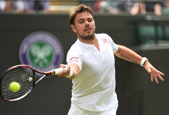 epa05396146 Stan Wawrinka of Switzerland returns to Taylor Fritz of the US during their first round match of the Wimbledon Championships at the All England Lawn Tennis Club, in London, Britain, 28 Jun ...