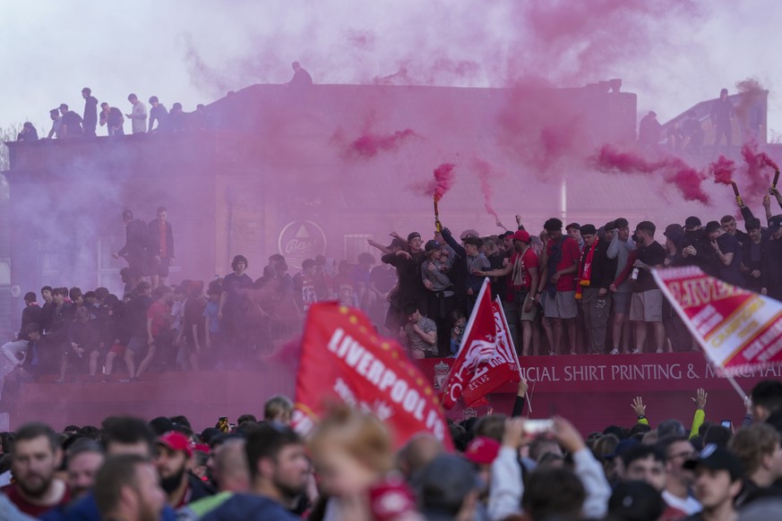 Liverpool supporters celebrate outside of Anfield stadium after their team won English Premier League soccer match against Tottenham Hotspur and clinched the Premier League title in Liverpool, England ...