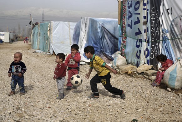 FILE - In this Jan. 22, 2016 file photo, Syrian refugee children play outside their family tents in a camp in the town of Saadnayel, in the Bekaa valley, Lebanon. The diplomatic spat this week between ...