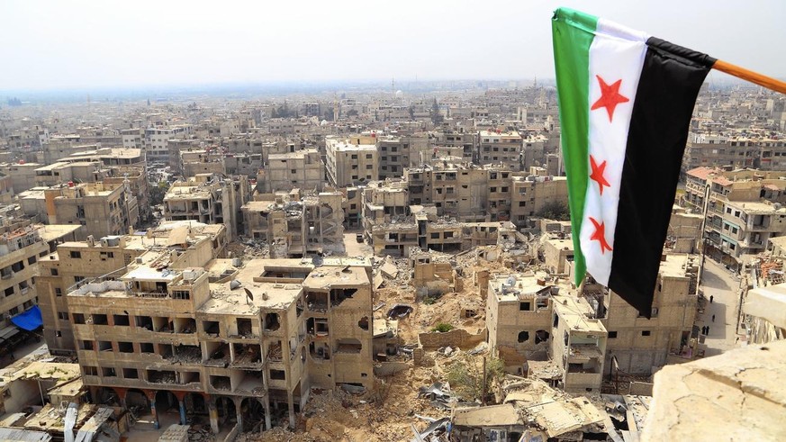Fahne der Freien Syrischen Armee (FSA) über der Stadt Duma bei Damaskus, wo 2012 erbitterte Gefechte zwischen FSA und Regierungstruppen stattfanden.