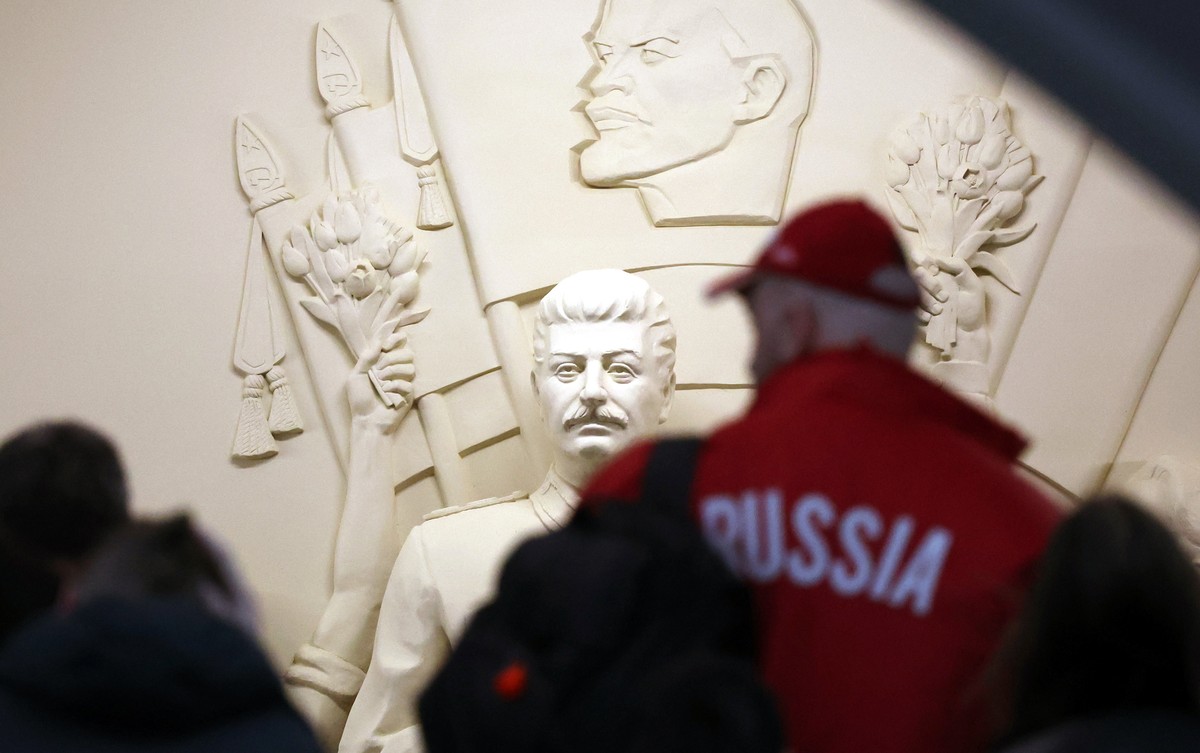 epa12102612 People walk in front of the replica of the high relief of Soviet leader Joseph Stalin during celebrations of the 90th anniversary of Moscow Metro at the Taganskaya metro station in Moscow, ...