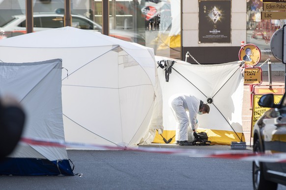 epaselect epa09846399 A forensic officer from the Vaud cantonal police investigates at the scene of the tragedy where four people died and one was seriously injured after falling from their flat in Mo ...