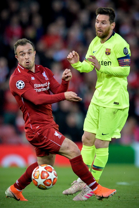 epa07554517 Liverpool&#039;s Xherdan Shaqiri (L) in action against Barcelona&#039;s Lionel Messi during the UEFA Champions League semi final second leg soccer match between Liverpool FC and FC Barcelo ...