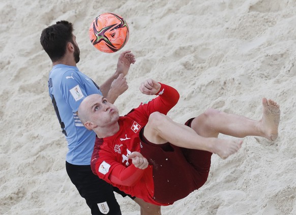 epa09430475 Richard Catardo (L) of Uruguay in action against Glenn Hodel of Switzerland during the FIFA Beach Soccer World Cup 2021 quarter final match between Uruguay and Switzerland at Luzhniki Beac ...