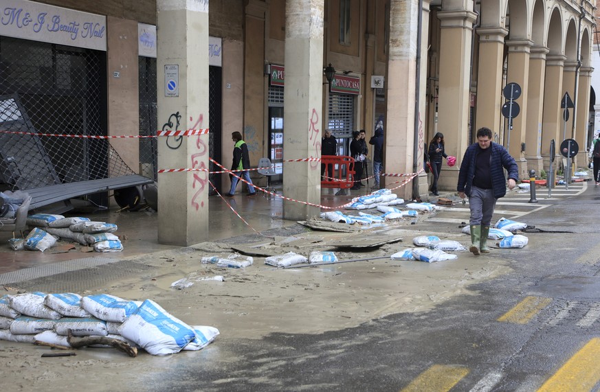 Mud and sandbags litter the side of a street as a shop is damaged after the underground Ravone Canal flooded, in Bologna, Italy, Wednesday, May 3, 2023. According to reports, a person in…
