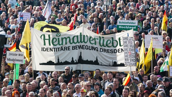 epa05587743 Supporters of the PEGIDA (Patriotic Europeans Against the Islamisation of the Occident) movement carry flags and placards as they gather on the Theatre Square in Dresden, Germany, 16 Octob ...