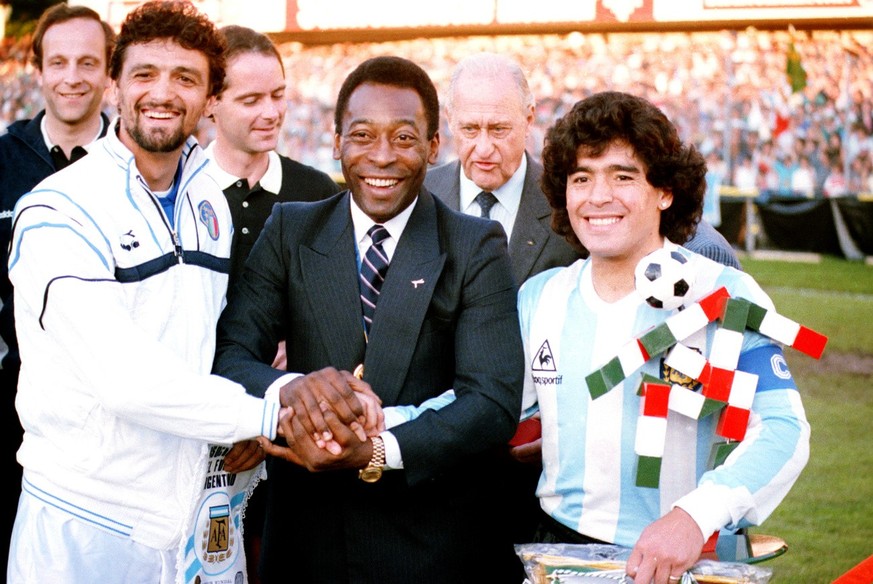 FILE - In this June 10, 1987 file photo, former Brazilian soccer player Pele, center, clasps hands with Italian captain Alessandro Altobelli, left, and Argentine captain Diego Maradona, after he is aw ...