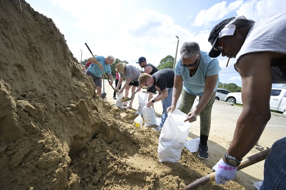 Johnny Ford, right, and his wife Jerria Ford fill free sand bags at an Orange County park in preparation for the arrival of Hurricane Ian, Monday, Sept. 26, 2022, in Orlando, Fla. (AP Photo/Phelan M.  ...