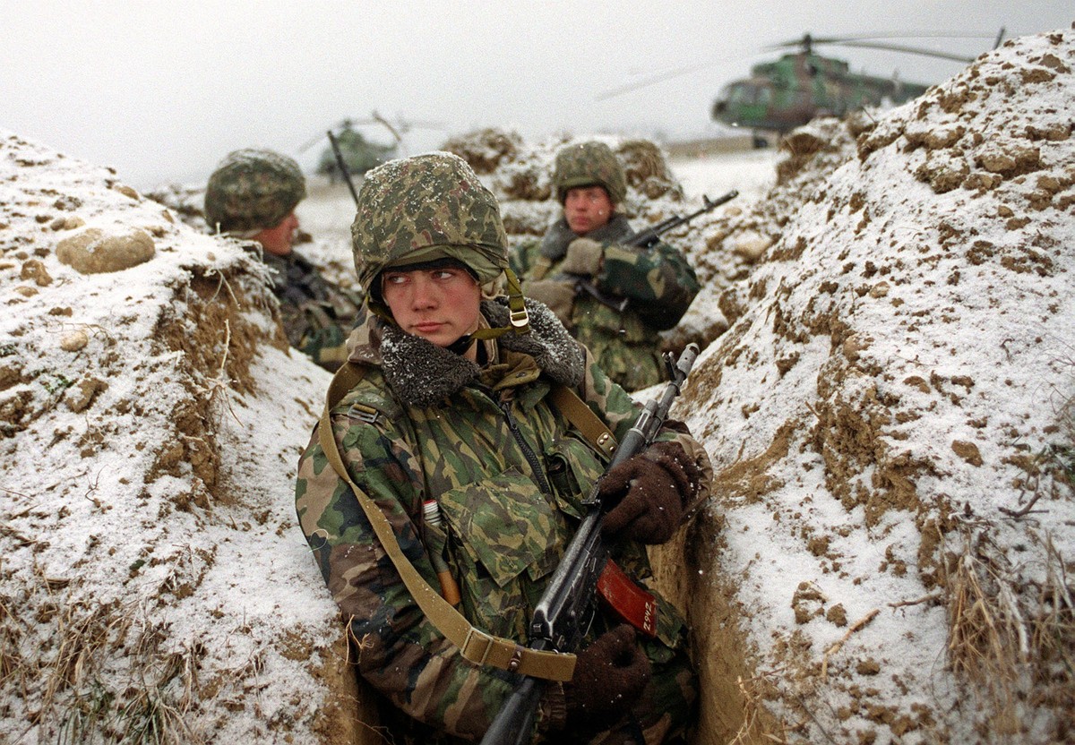 Russian soldiers hiding in a trench guard a military airfield in Shali 25 km ( 16 miles) southeast of Grozny, Chechen capital, Sunday, Jan. 21, 2001. The Russian President on Monday transferred contro ...