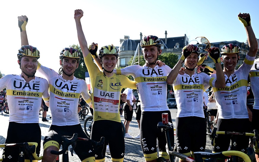 epa09352371 Slovenian rider Tadej Pogacar (C-L) of the UAE-Team Emirates wearing the overall leader&#039;s yellow jersey celebrates with teammates after the 21st stage of the Tour de France 2021 over  ...