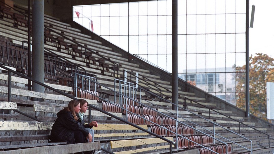 Zwei Zuschauerinnen verlieren sich am Donnerstag, 21. Oktober 1999 auf der Haupttribuene des Stadions Wankdorf in Bern, um das Training der ersten Mannschaft des NLB Fussballklubs BSC Young Boys zu ve ...