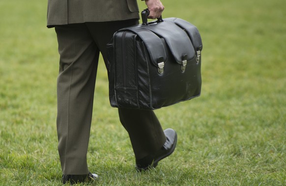 epa05007957 A Major in the US Marine Corps carries a briefcase known as the &#039;football&#039;, which contains materials that could be used by the president to authorize a nuclear attack, while walk ...