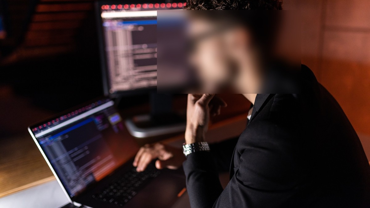 Junger Mann vor Laptop, Gesicht verpixelt. Symbolbild für Überwachung.