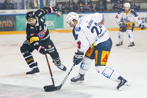 Le defenseur fribourgeois Philippe Furrer, gauche, lutte pour le puck avec le defenseur zougois Santeri Alatalo, droite, lors de la rencontre du championnat suisse de hockey sur glace de National Leag ...