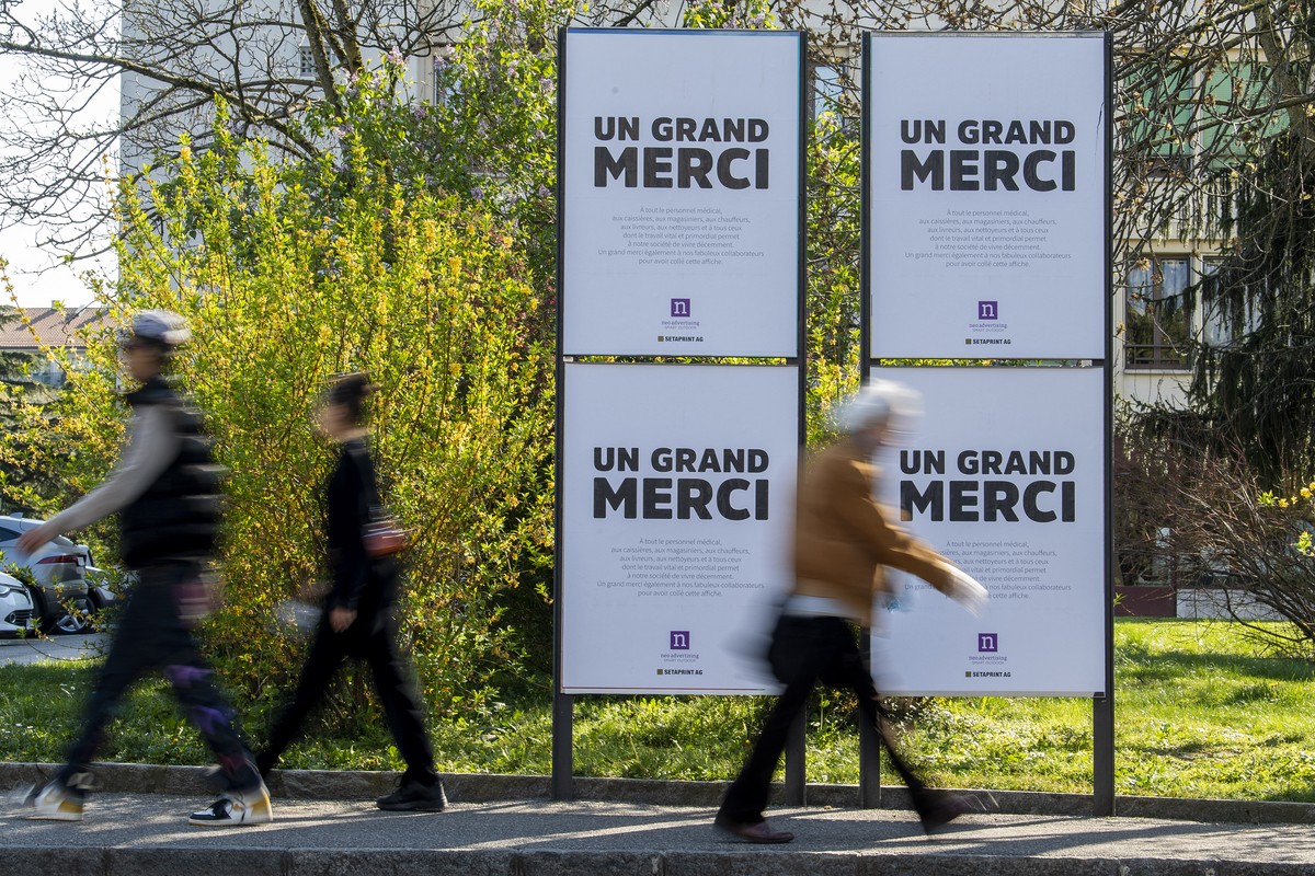 Des personnes passent devant des affiches ou il est ecrit " Un Grand Merci " la societe d'affichage Neo advertising qui a lance cette initiative de remerciements a tout le personnel med ...