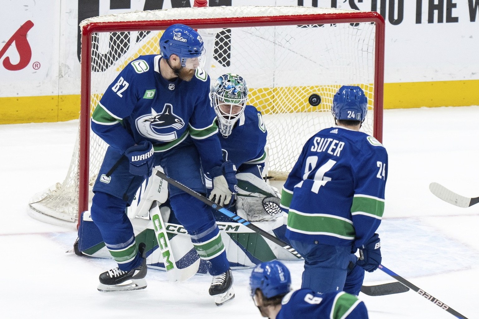 Vancouver Canucks goalie Arturs Silovs gives up a goal to Edmonton Oilers&#039; Mattias Ekholm, not seen, as Ian Cole, front left, and Pius Suter watch during the first period of Game 1 of a second-ro ...
