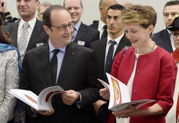 epa04706650 Simonetta Sommaruga, Swiss Federal President, right, and French President  Francois Hollande, read cookery books, during a visit to the Swiss cleantech entreprise &quot;Ernst Schweizer AG Metallbau&quot; in Hedingen in the Canton of Zuerich, Switzerland,  16  April 2015 on the final day of his two day visit.  EPA/STEFFEN SCHMIDT