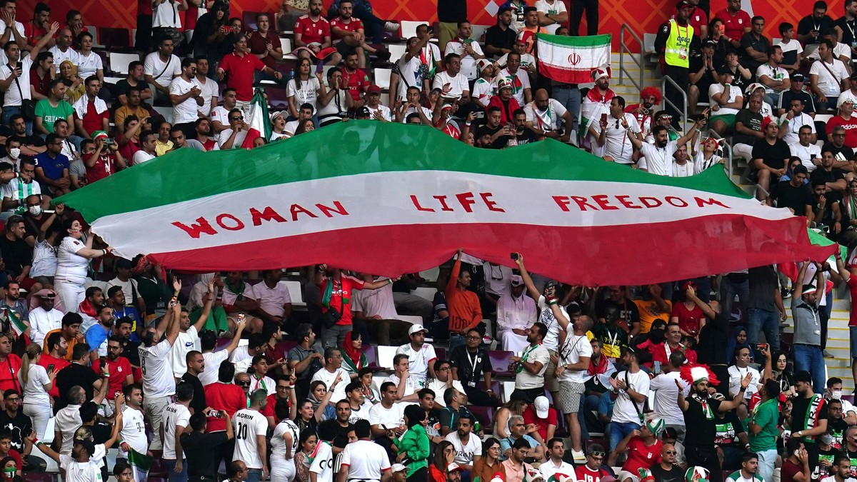 England v Iran - FIFA World Cup, WM, Weltmeisterschaft, Fussball 2022 - Group B - Khalifa International Stadium Iran fans in the stands hold up an Iran flag reading Woman Life Freedom during the FIFA  ...