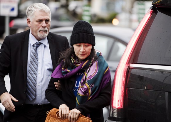 Huawei chief financial officer Meng Wanzhou arrives at a parole office with a security guard in Vancouver, British Columbia, Wednesday, Dec. 12, 2018. (Darryl Dyck/The Canadian Press via AP)