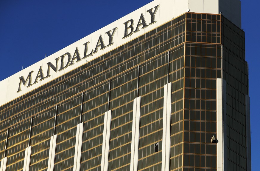 epa06240348 Curtains blow out of broken windows on a high floor in the Mandalay Bay hotel facing thescene of the mass shooting at the Route 91 Harvest festival on Las Vegas Boulevard in Las Vegas, Nev ...