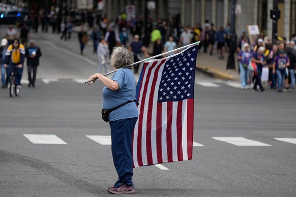 A person holds an American flag before a &quot;No Kings&quot; protest Saturday, Oct. 18, 2025, in Chicago. (AP Photo/Nam Y. Huh)
US Protests Chicago