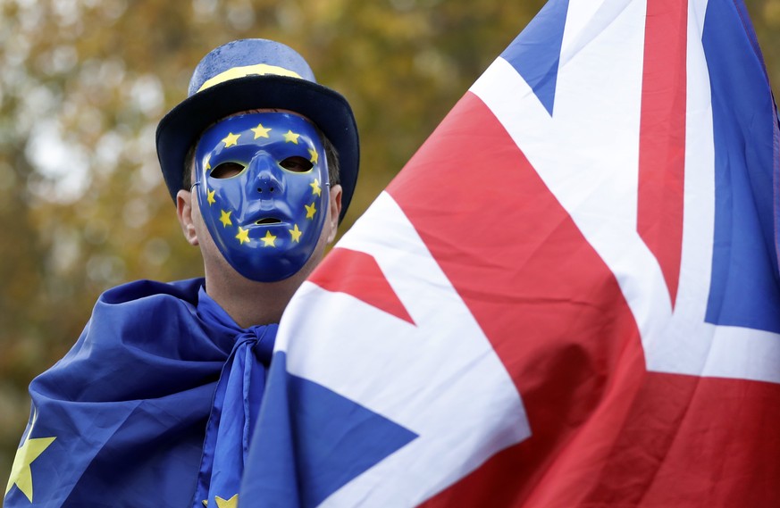 An anti-Brexit, pro European Union campaigner holds a Union flag, near Parliament in London, Wednesday, Nov. 22, 2017. Britain&#039;s Treasury chief has little room to maneuver Wednesday as he reveals ...