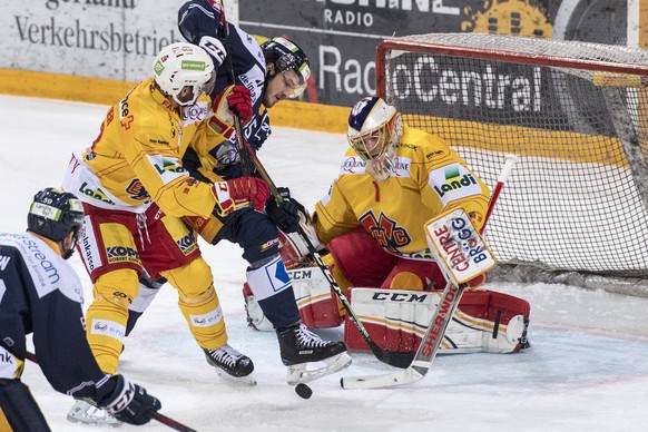 Dennis Everberg, mitte, von Zug im Spiel gegen Torhueter Jonas Hiller, rechts, und Beat Forster, links, von Biel beim Eishockey Meisterschaftsspiel in der Qualifikation der National League zwischen de ...