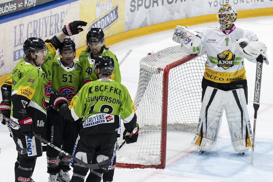 Gotterons Spieler feiern neben Ajoies Torhueter Tim Wolf den Treffer zum 7-2 im Eishockey Qualifikationsspiel der National League zwischen dem HC Fribourg Gotteron und dem HC Ajoie, am Dienstag, 10. J ...